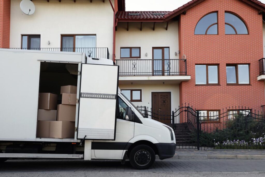 Van with moving boxes near apartment or condominium complex.