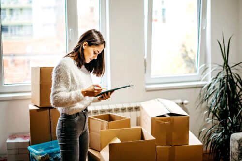 A woman looks over the boxes she is unpacking in her new apartment.